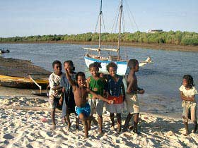 Spielende Kinder am Strand eines Fischerdorfes